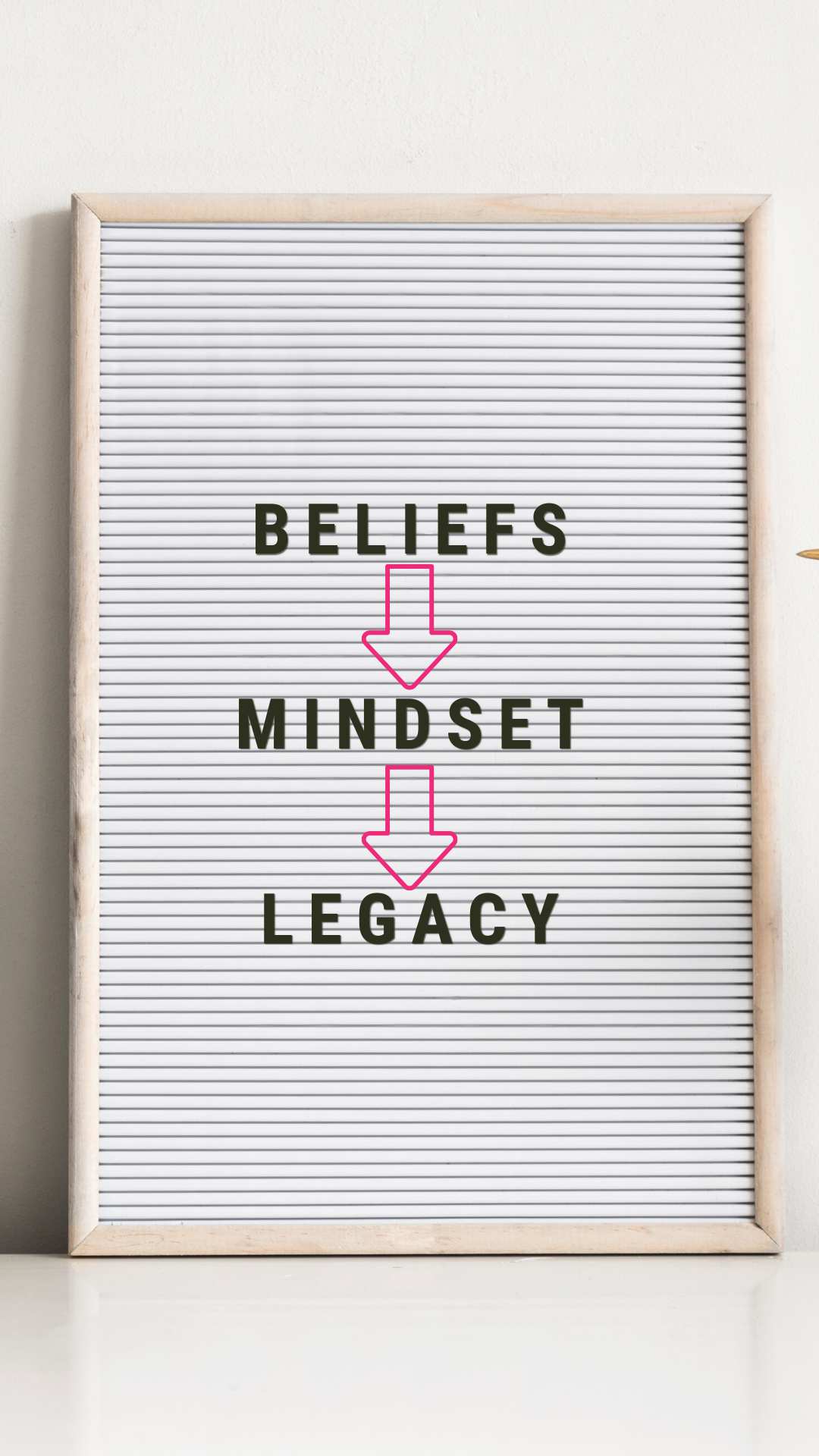 white message board with light tan wooden frame with the words "BELIEFS --> MINDSET --> LEGACY"