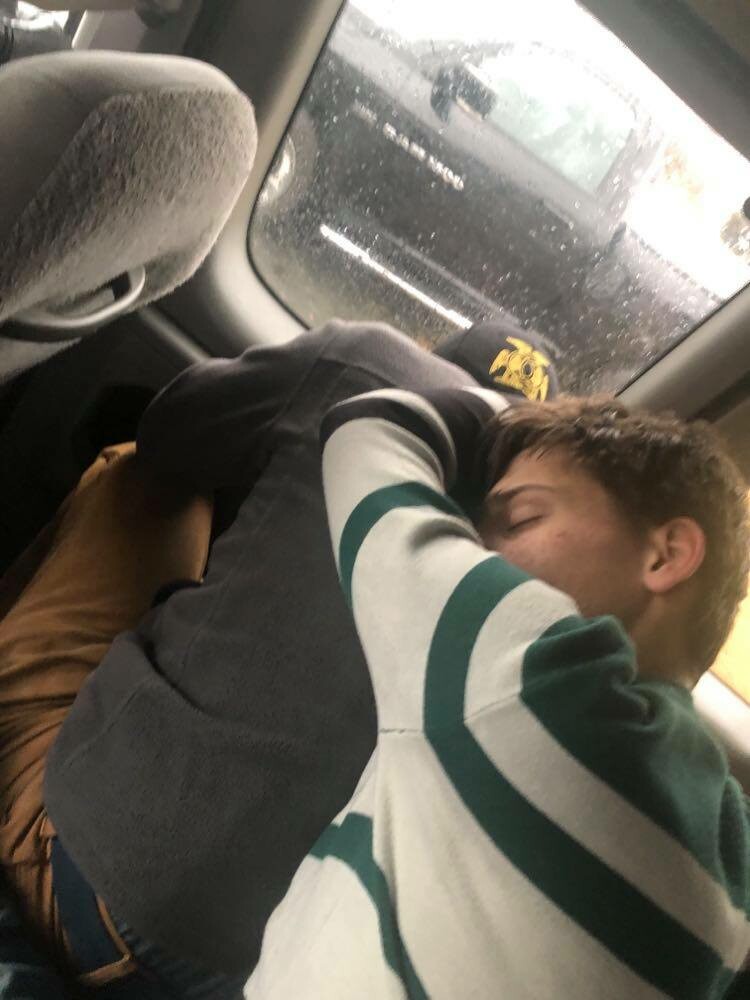 Two big young men asleep on a longer car ride. 