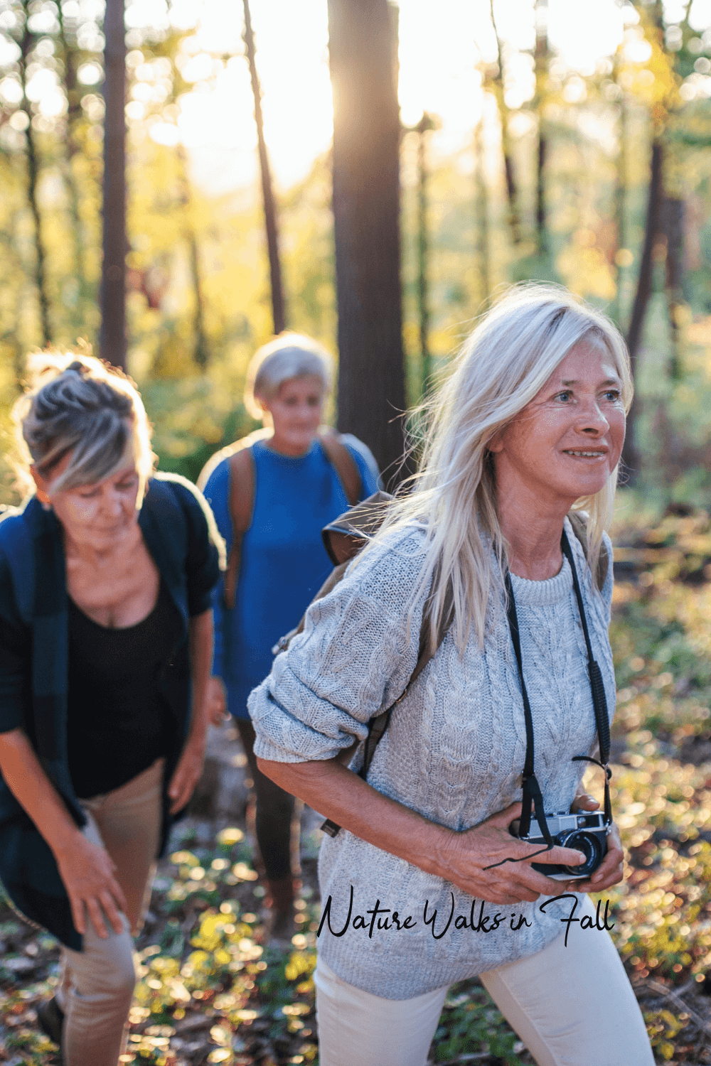 Women hiking through a sunlit autumn forest, symbolizing natural energy, outdoor movement, and wellness habits to beat the seasonal slump.