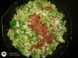 adding the cooked bacon to the chopped brussel sprouts