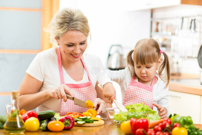 Mother and kid girl preparing healthy food. Mom and kid girl preparing healthy food royalty free stock photography