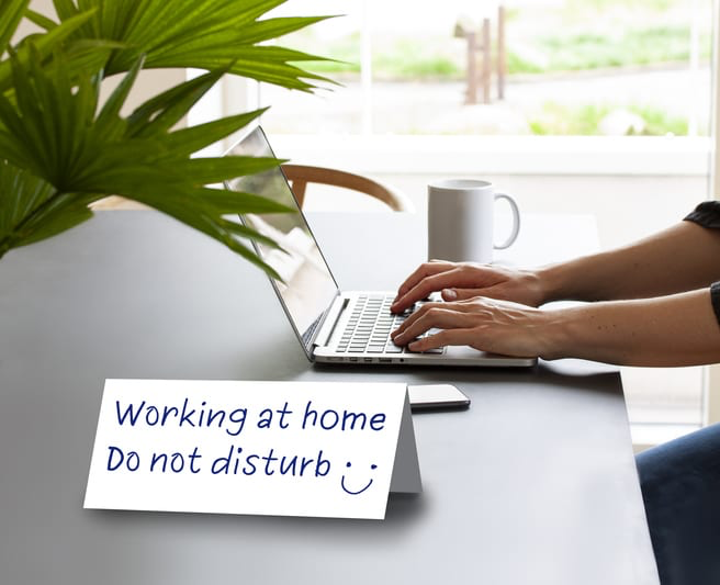 Sign on desk that says "Working at home. Do not disturb."