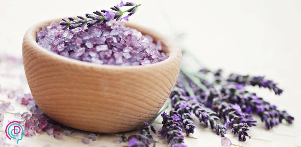 "Epsom salt and fresh lavender flowers arranged beside a warm bath, creating a relaxing and soothing spa-like atmosphere.