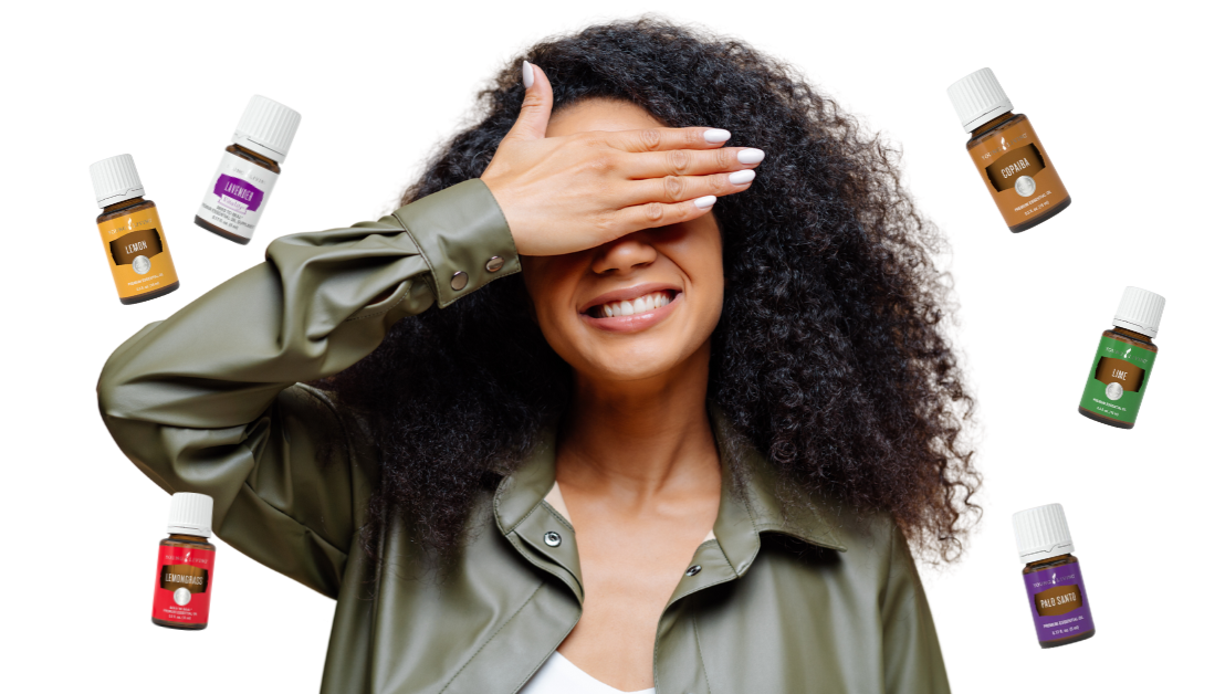 Woman smiling while lightly covering her eyes while essential oil bottles float in the air around her.