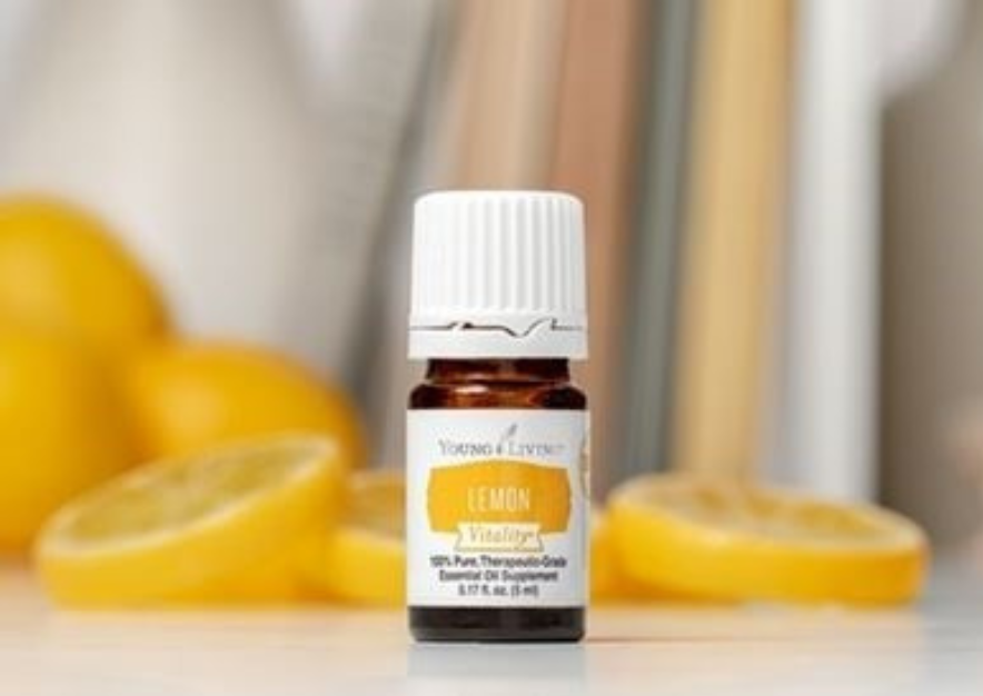 a bottle of Young Living lemon vitality essential oil in front of sliced lemons