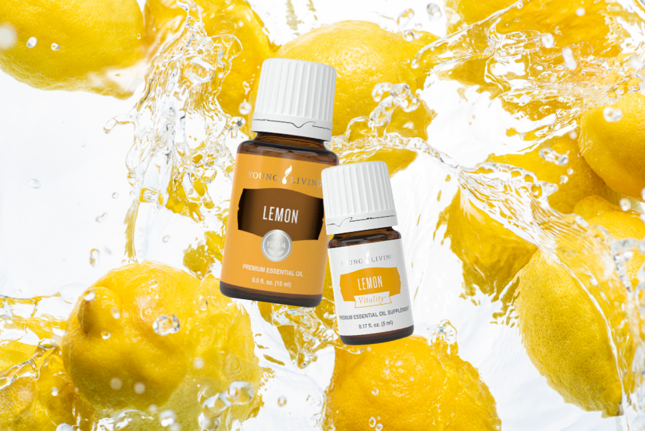 Two bottles of Young Living lemon essential oil. One 15 ml and one 5 ml vitality in front of lemons spashing in fresh water