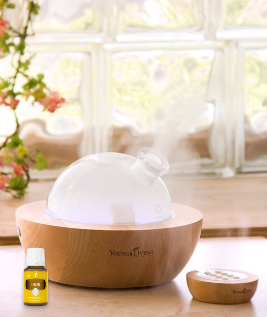 bottle of Young Living lemon essential oil next to an Aria diffuser