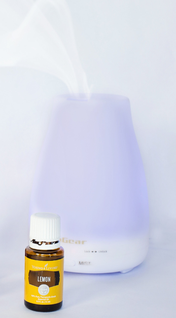 A bottle of Young Living Lemon essential oil in front of a diffuser