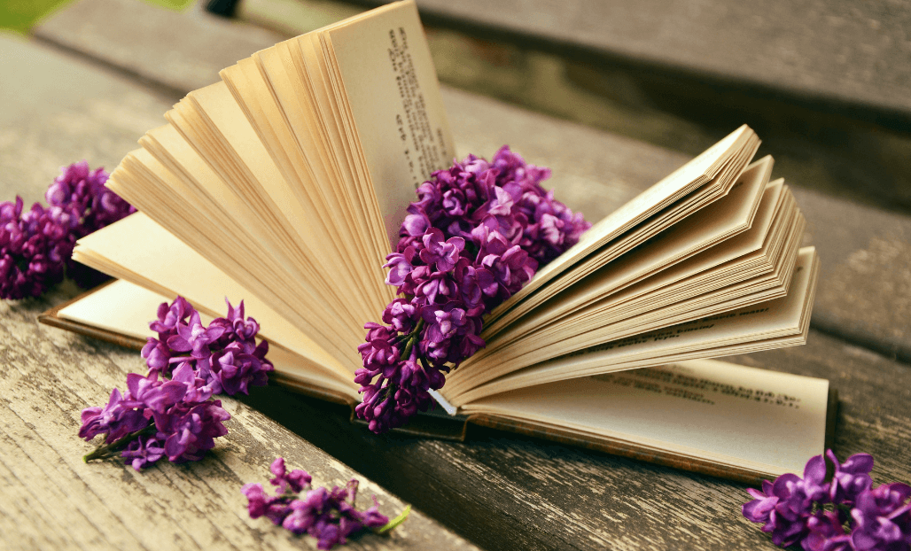 open journal with lilac blossoms laying on and around for post titled Journal Prompts to Unlock Creativity, Clarity, and Focus!