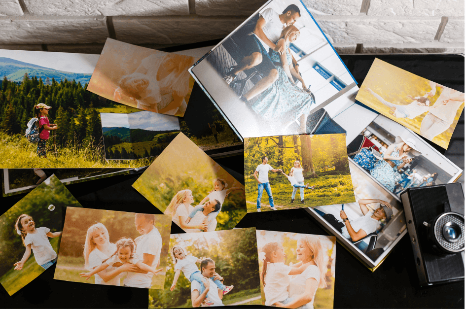 photos of outdoor family activities laid out on a black table next to a camera for post titled Energize Your Winter Journals with Images!