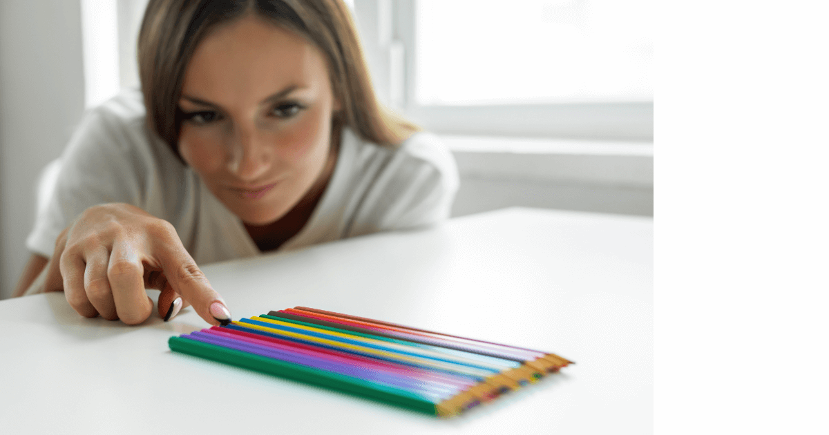 woman carefully lining up colored pencils in perfect order for post titled 6 Fun and Silly Journaling Ideas 
