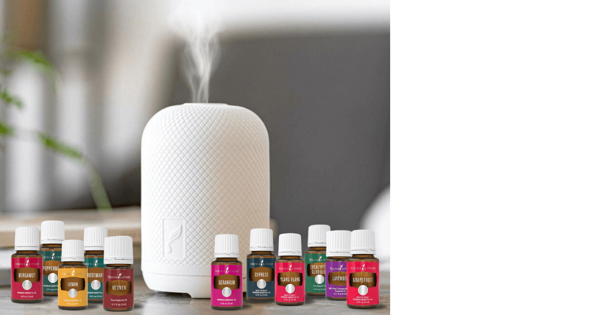 A Haven diffuser is closeup in the blurred out room background with 11 Young Living essential oils that could be used as diffuser blends sit next to it for post titled Spring Aromatherapy: Refreshing Diffuser Recipes