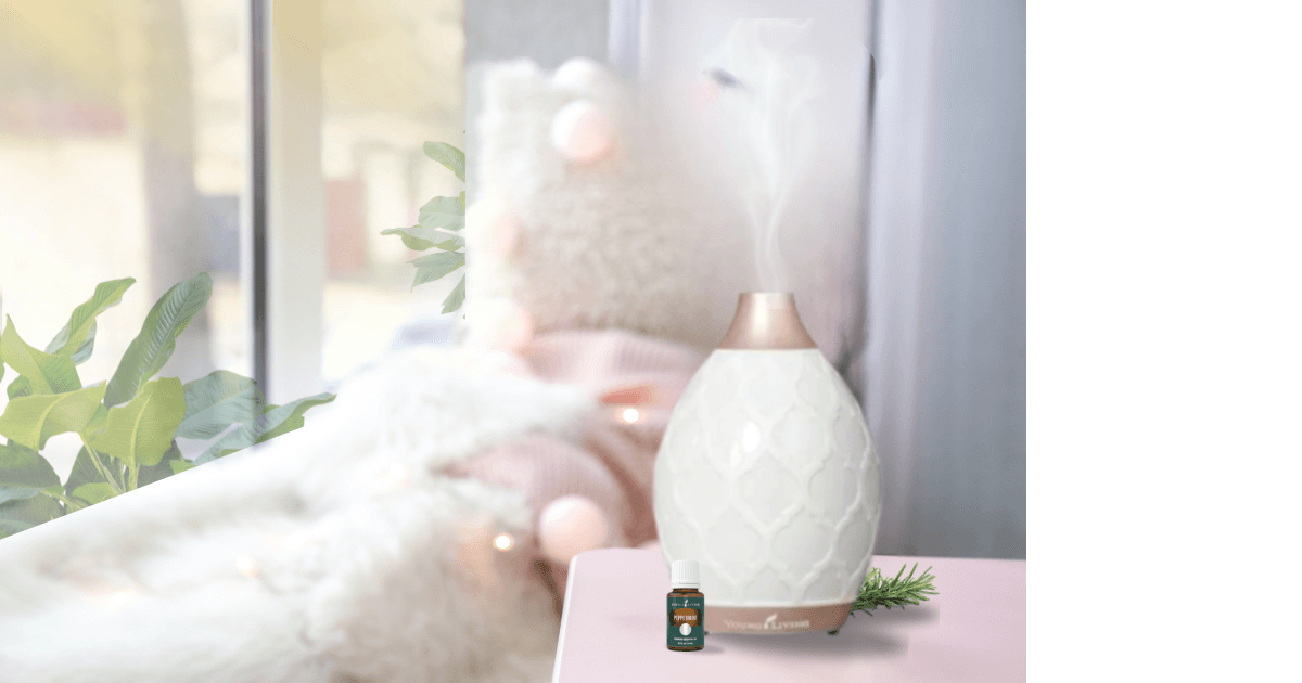 a light pink haze of a room with a big window next to a day bed and a Desert Mist diffuser with a Young Living essential oil next to it on a pinkish tabletop for post titled Spring Aromatherapy: Refreshing Diffuser Recipes