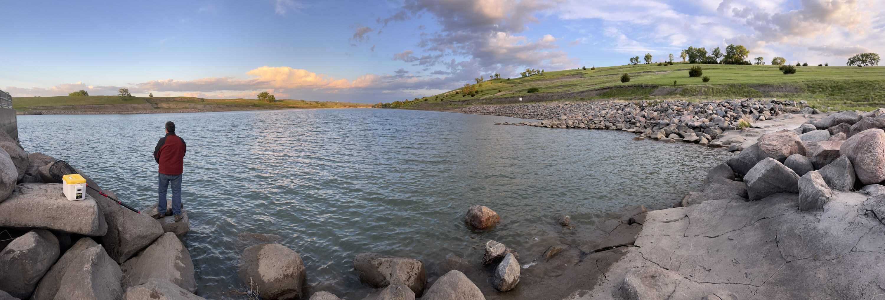 Allen standing on the rocks at Oahe resevoir near Ft Pierre, SD, at sunset casting into the water for a blog post titled Reeling in the Benefits of a Fishing Journal