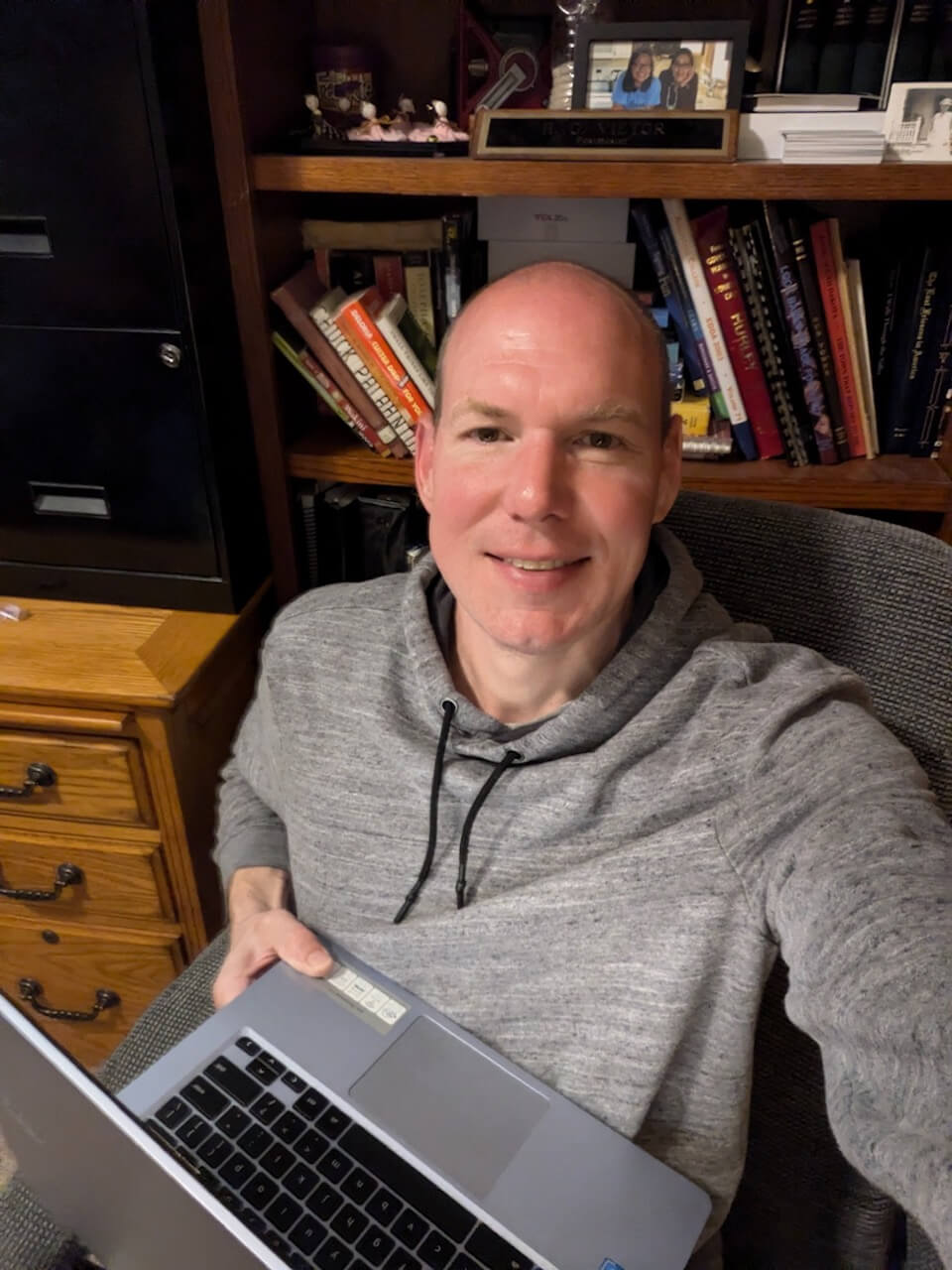  Jordan Hofer, author, sitting in his office with his laptop for a bound to journal blog post titled Never There Long: A Journal Series by Jordan Hofer