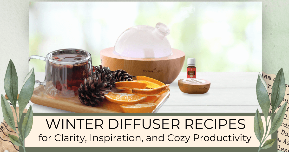 Young living Aria diffuser, an essential oil, and a tray of hot tea, pinecones and sliced oranges on a white countertop for a blog post titled Winter Diffuser Recipes for Clarity, Inspiration, and Cozy Productivity