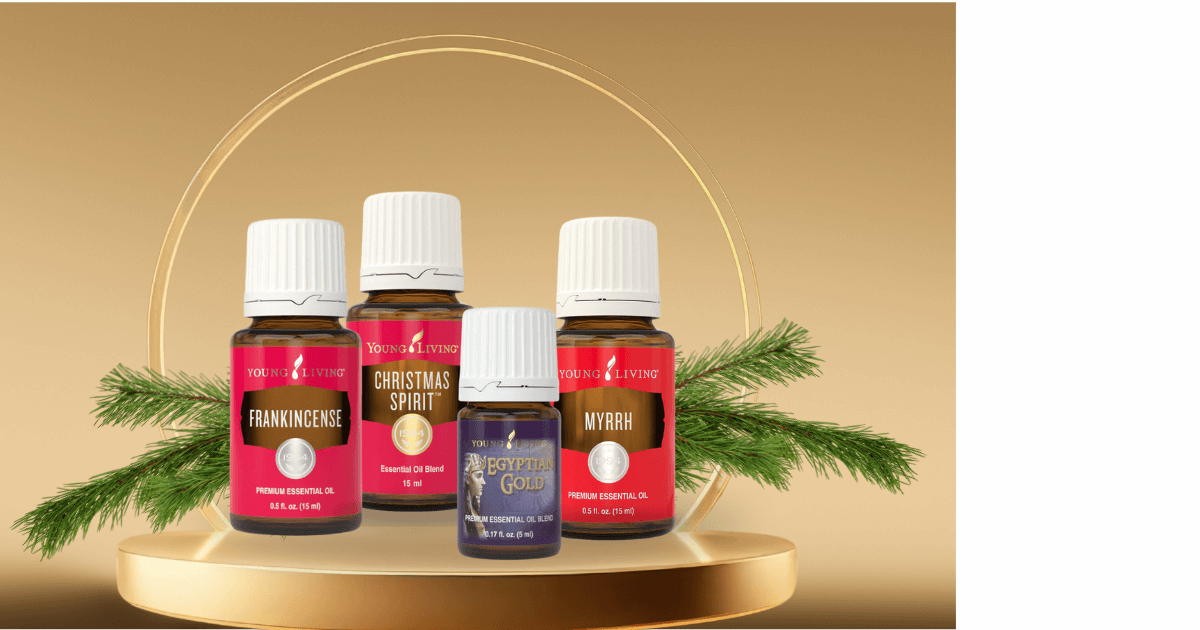  Sitting on a golden pedistal with a gold reing haylowing, are 4 essential oils (Frankincense, myrrh, egyptian gold, and Christmas spirit) and greenery  for a blog post titled Ancient Oils: The Perfect Companion for Holiday Journaling