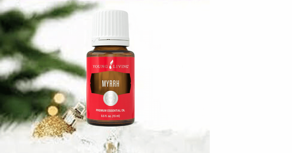  A bottle of young living myrrh essential oil near a gold christmas ornament and branches from an evergreen in the background for a blog post titled Ancient Oils: The Perfect Companion for Holiday Journaling