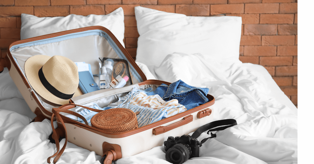  An open suitcase sitting on a bed that clearly displays a bag of essential oils and young living products  for our Bound to Journal blog post titled Traveling with Essential Oils: Your Ultimate Guide to Serenity on the Go