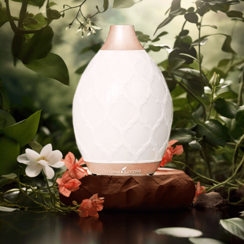 A green foliage background, a white diffuser sitting on a wood plank, and both white and orange blossoms surround it for a Bound to Journal blog post titled, "Embrace Fall: How Aromas and Nature Support Mood, Memory, and Journaling."