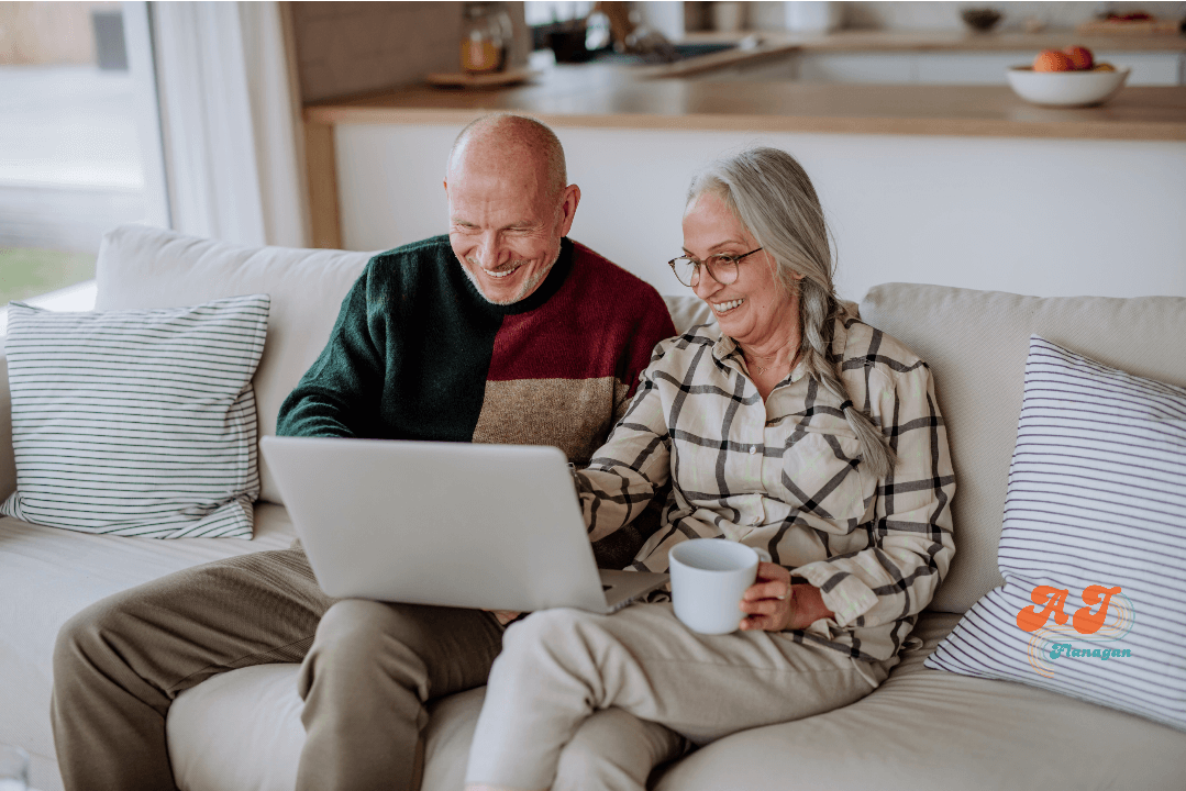 A couple, relaxing on their sofa while planning their trip using a laptop