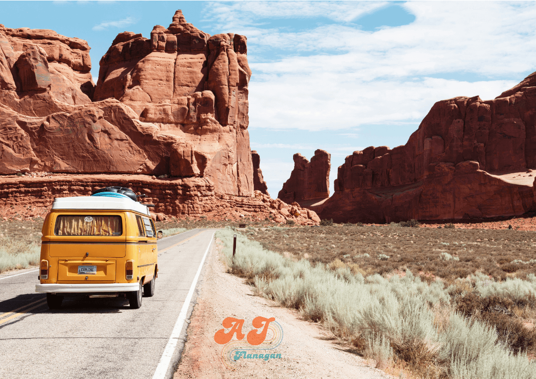 Volkswagen bus on a road with rock formations all around