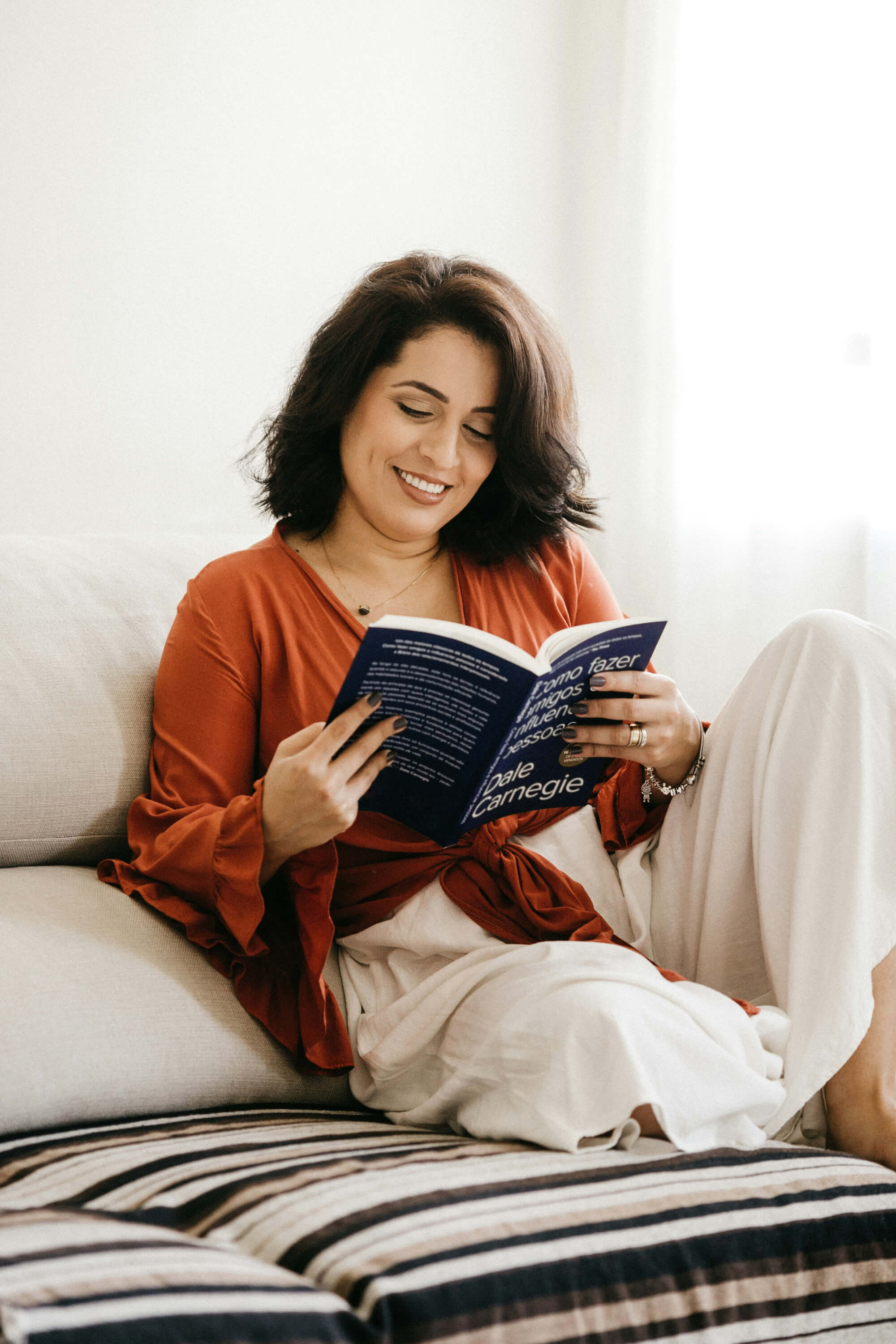 Woman reading a book while lounging on comfortable furniture 