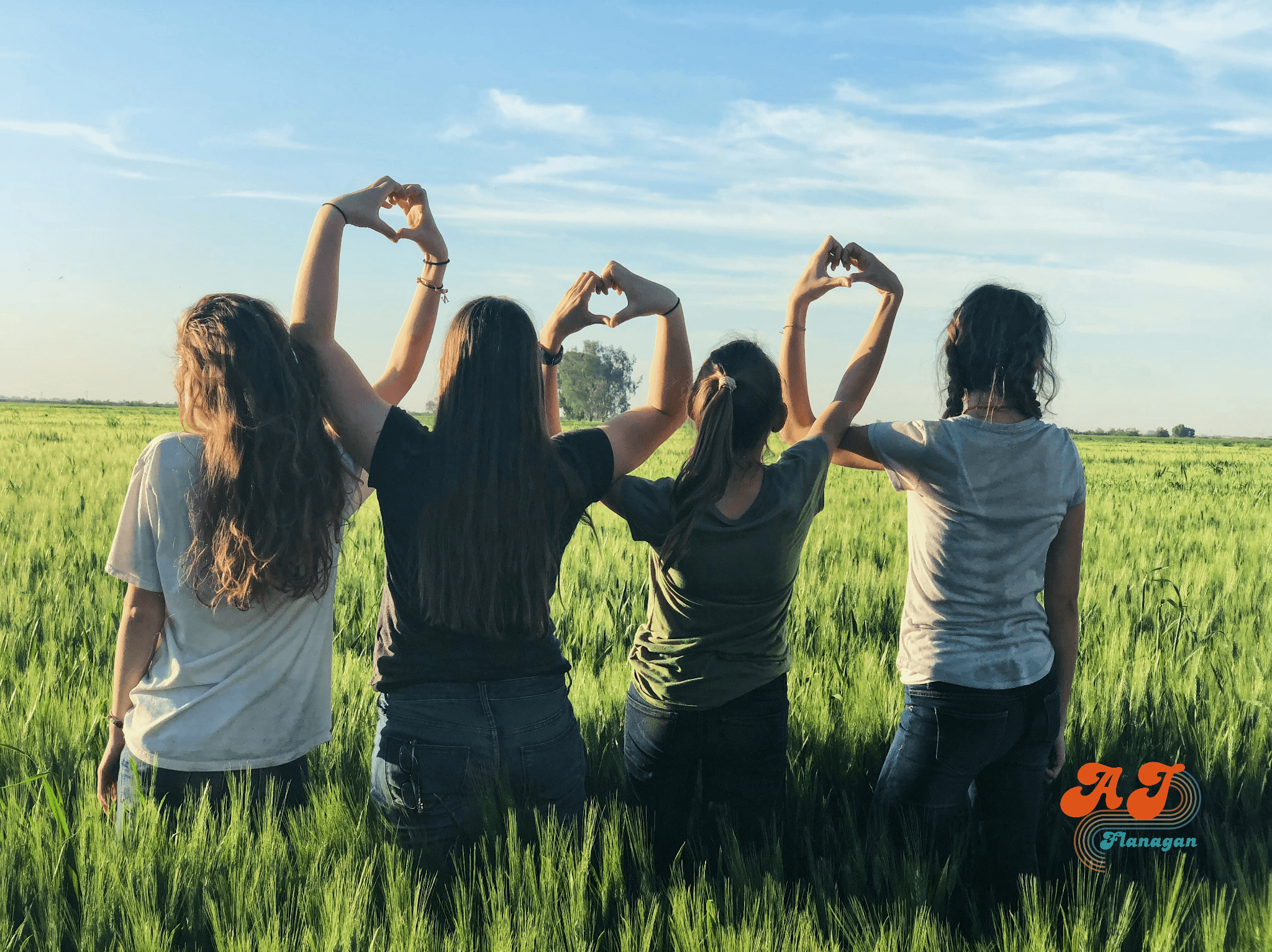 Four friends making "heart hands" together