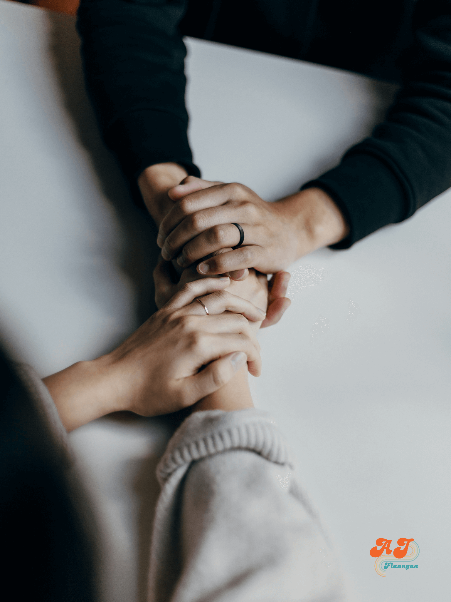 Supportive friends holding hands across a table