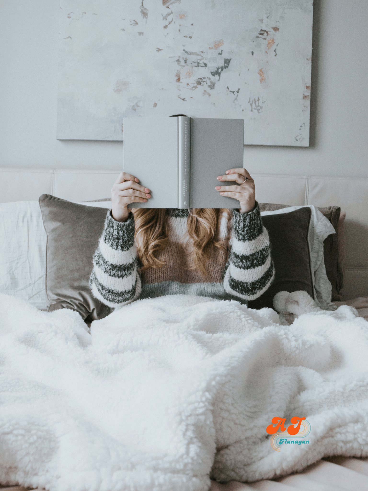  Cocooning; woman cuddled up in bed with a book